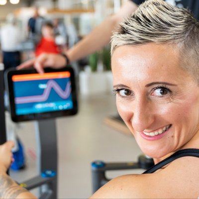 Sportpark Quickborn: Eine Frau hat Spaß beim Fitness Training und lächelt in die Kamera.