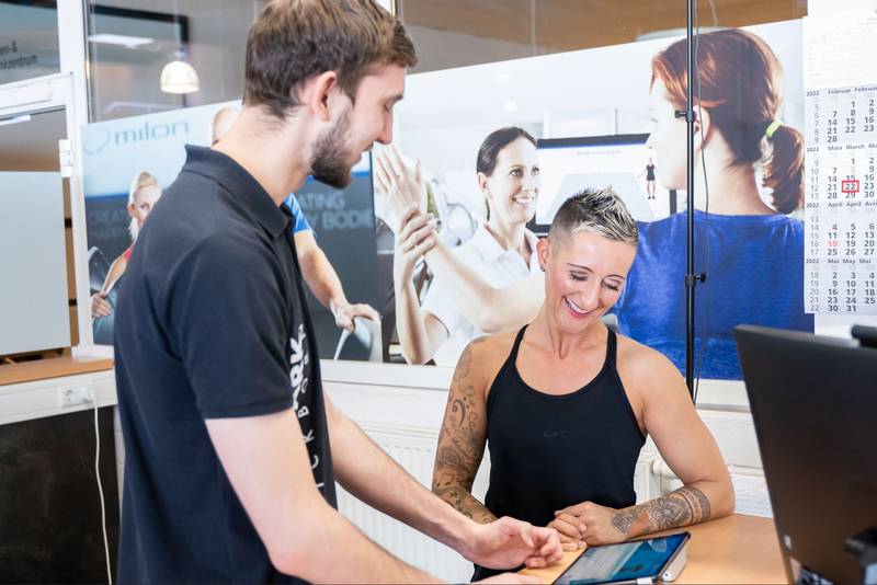 Sportpark Quickborn: Eine Frau lässt sich im Fitnesscenter von einem Trainer über die Leistungen beraten.